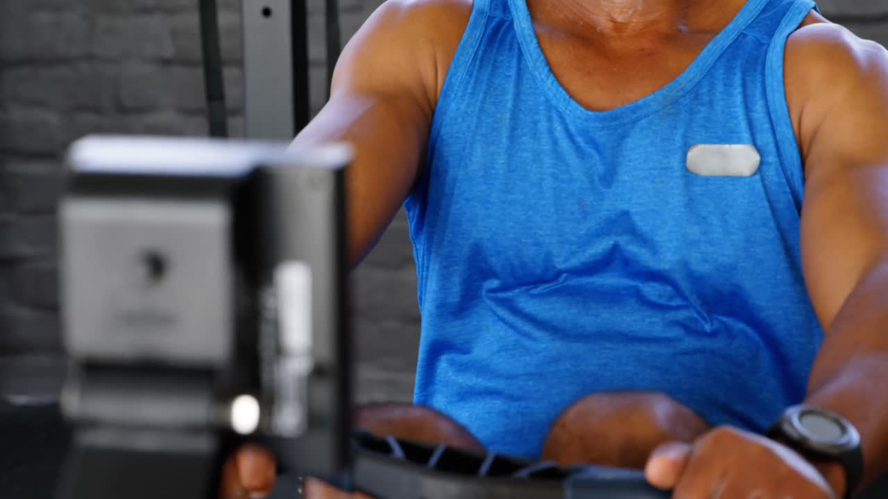 피트니스 스튜디오 4k에서 로잉 기계에서 일하는 고위 남성