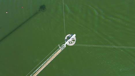 birds eye view drone shot of a waterski system - drone is watching an active rotor