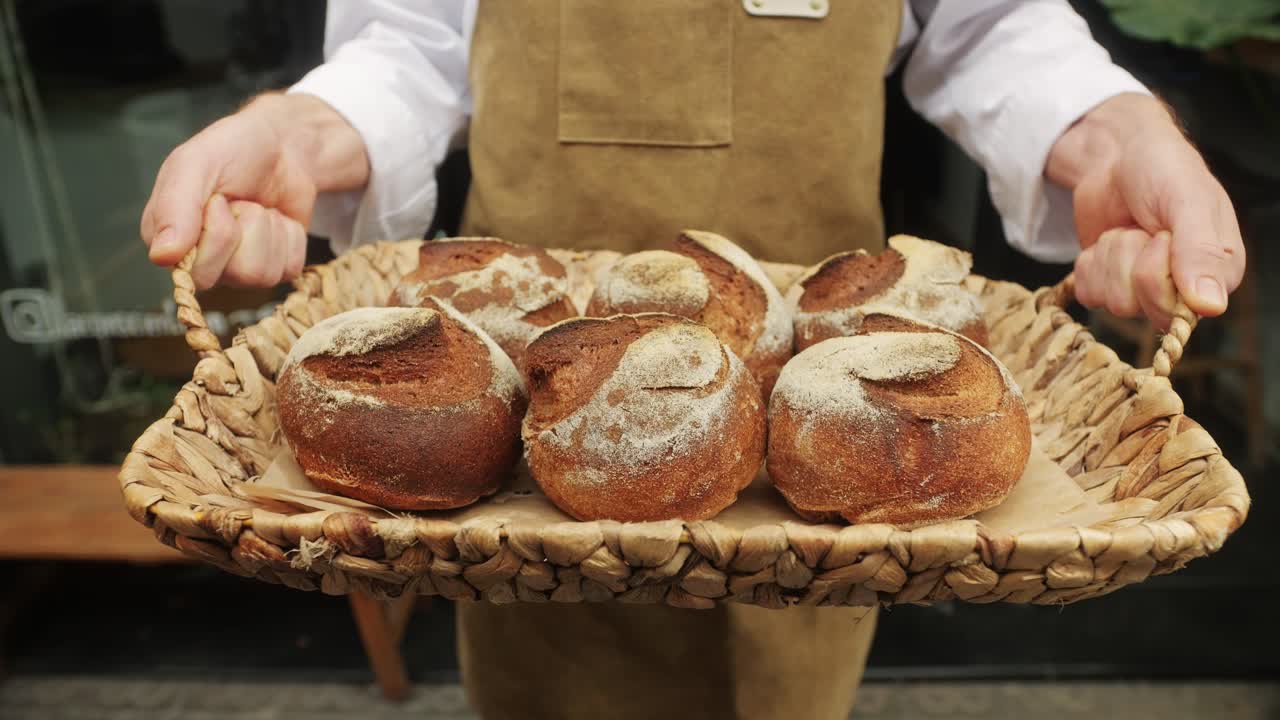 The baker holds in hands a of fresh bread close-up. Artisan bread is making by skill bakers using natural and high-quality ingredients. Food with health and flavour benefits.