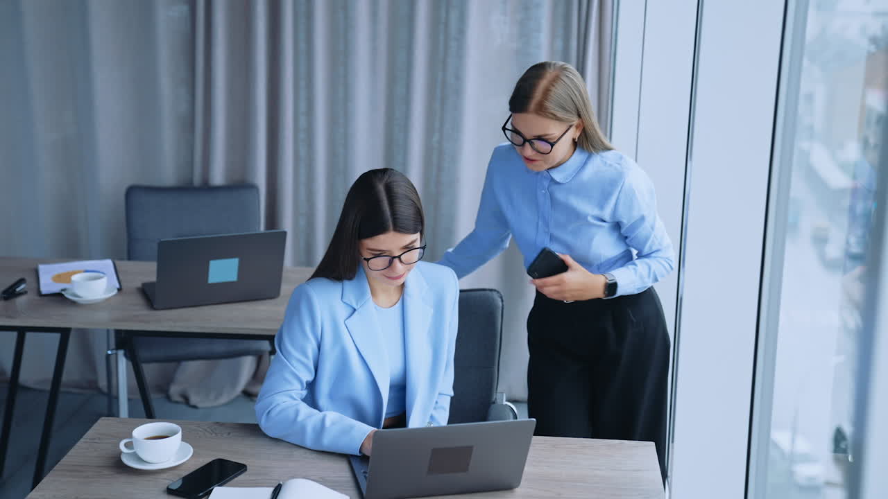 dos mujeres de negocios colaborando en una oficina moderna