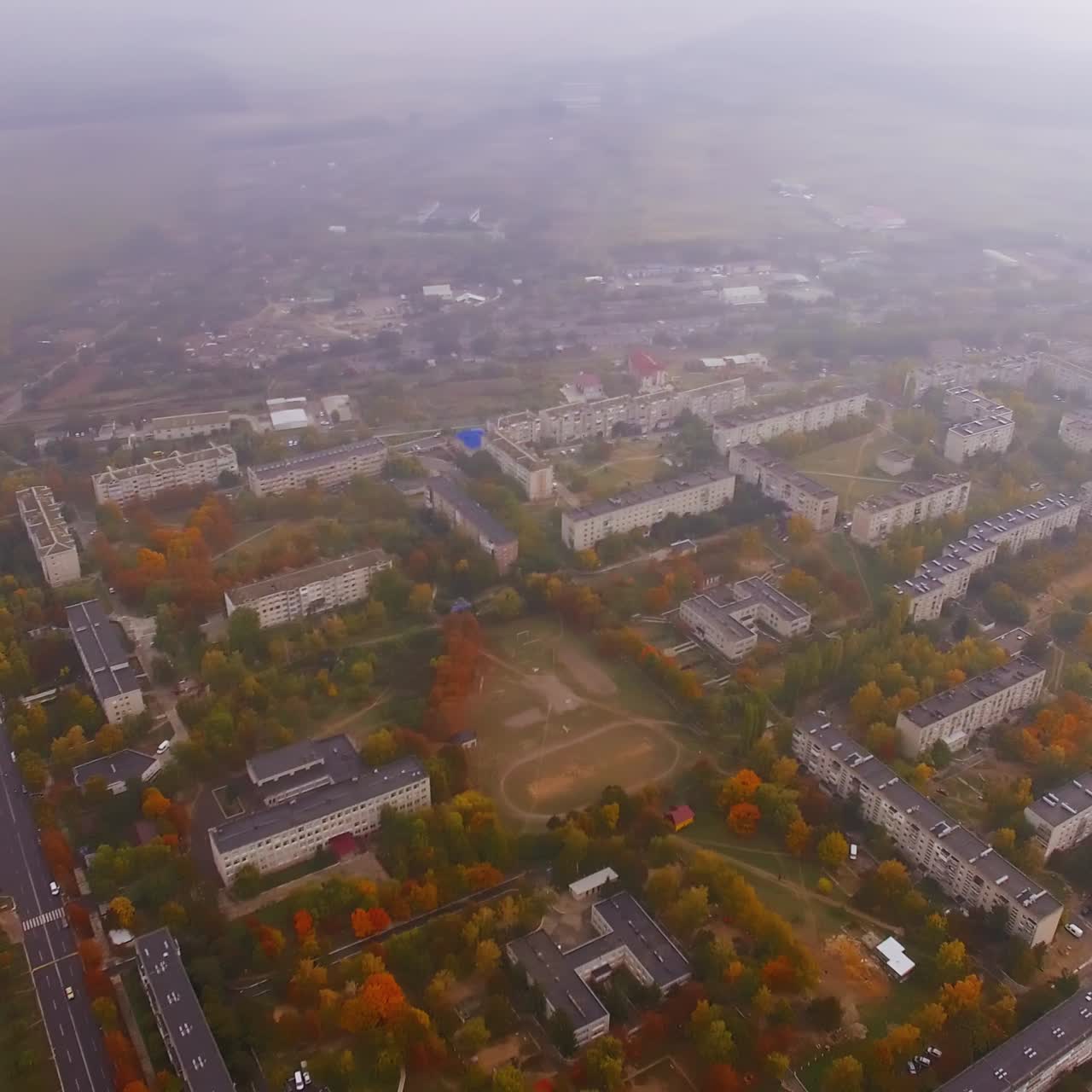 Hazy view of urban landscape on dull autumn day. Circling footage over the residential districts of provincial city