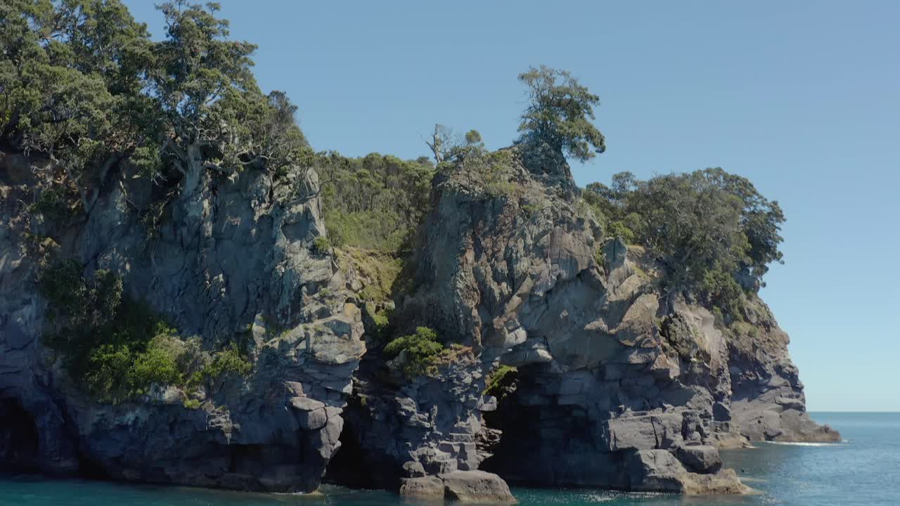 Kayaking along scenic cliffs of Whale Island, New Zealand travel destination