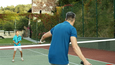 Rückansicht-Eines-Mannes,-Der-An-Einem-Sonnigen-Sommertag-Mit-Seinem-Jugendlichen-Sohn-Tennis-Spielt