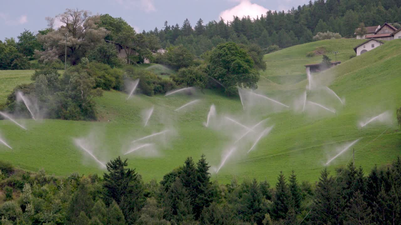 Switched-on irrigation system on a mountain meadow above Laas - Lasa, South Tyrol, Italy