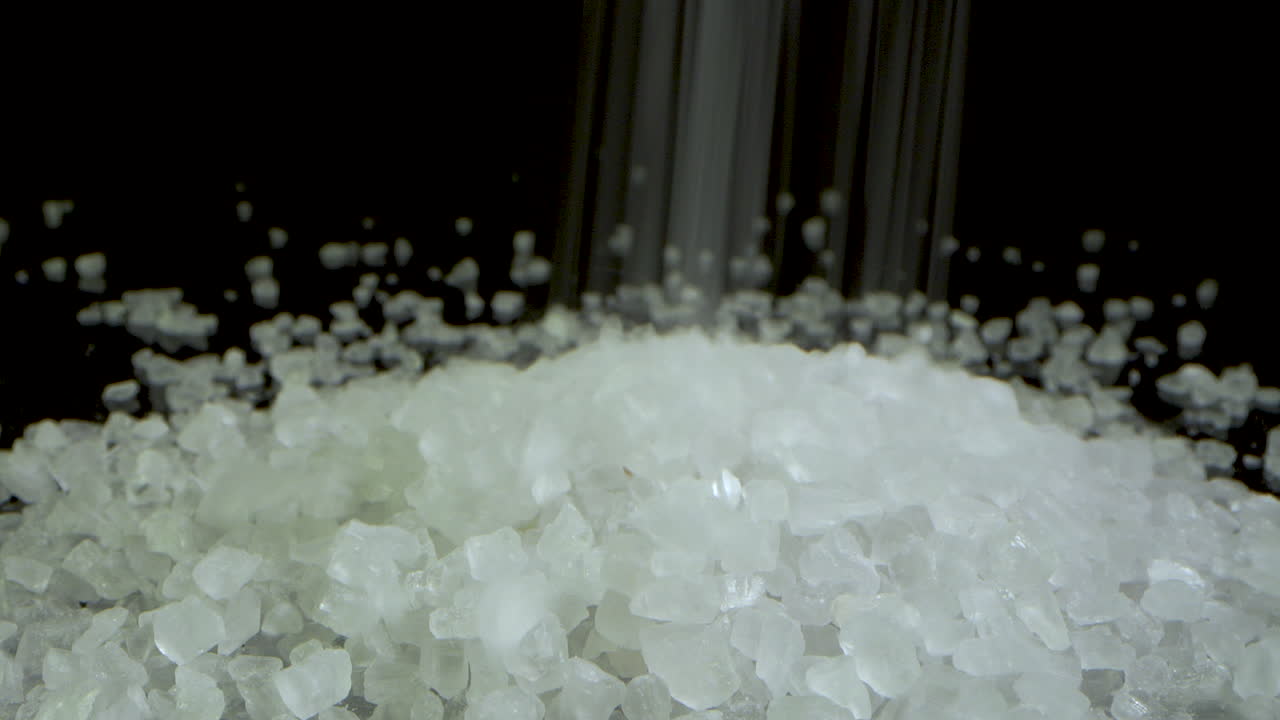 블랙 테이블에 있는 크리스탈 거친 바다 소금 언덕의 느린 앞으로 카메라