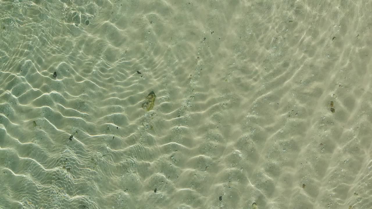 Aerial Drone top down View of green sea water texture. 4K Background of Azure ocean crystal clear water with ripple on surface.
