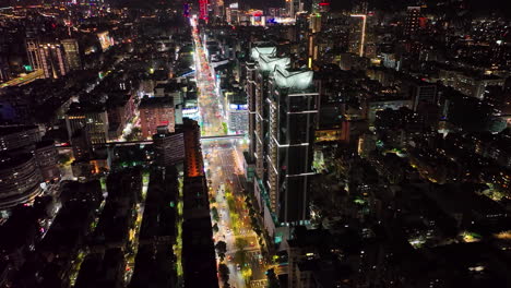 Toma-Nocturna-Aérea-De-Las-Torres-De-Taipei,-La-Torre-101-Y-Las-Luces-De-Los-Autos-En-La-Carretera-Por-La-Noche,-Taiwán