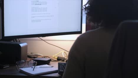 productive workday: unrecognizable caucasian man with long curly hair and glasses working from home