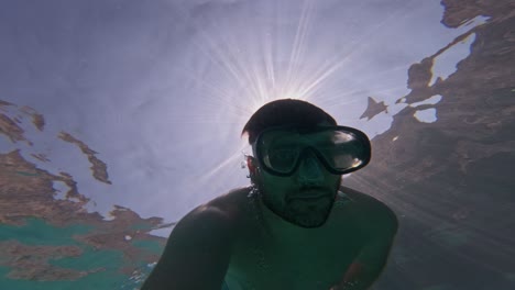 man in goggles swimming in the ocean. - underwater shot