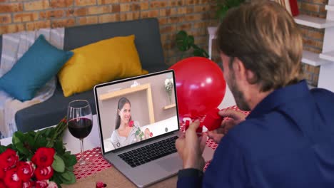 caucasian couple on a valentines date video call man showing ring to smiling woman on laptop screen