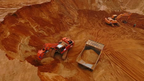 maquinaria de minería que trabaja en la mina de arena. excavadora vertiendo arena en el camión de minería