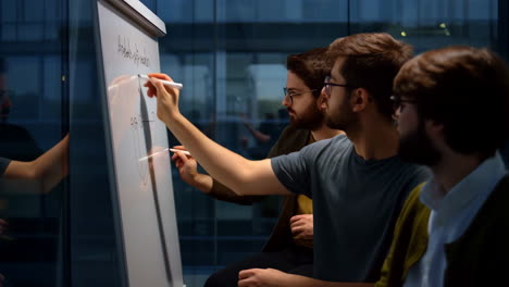 Men Collaborating and Brainstorming on a Whiteboard in an Office Setting