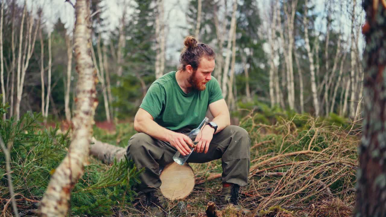 Portrait Of A Norwegian Guy Drinking Water From A Bottle In A Forest. Static Shot