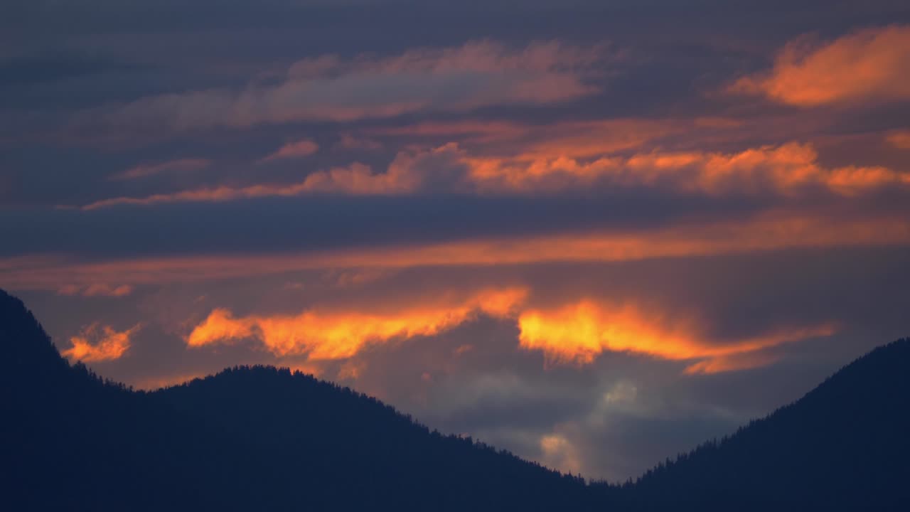 Colorful Sky Over Silhouetted Forest Mountains During Dusk