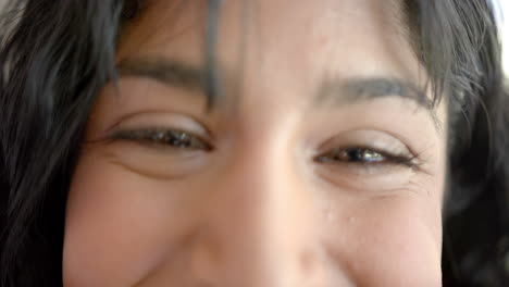 portrait of happy biracial female teenager with long hair at home, slow motion