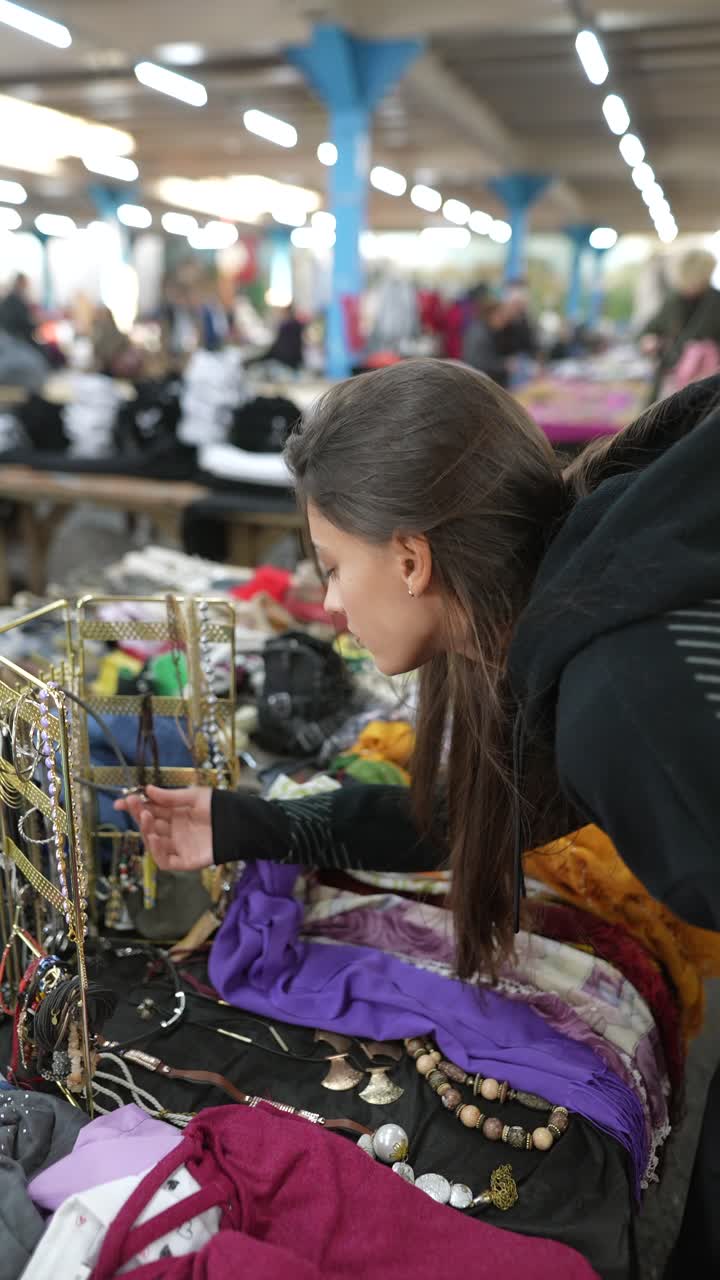 mujer revisando joyas en un mercado de pulgas