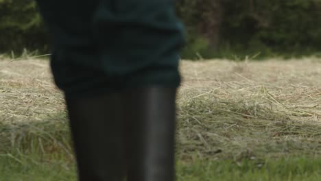 Farmer-man-walking-through-mowed-grass-field-in-his-private-property