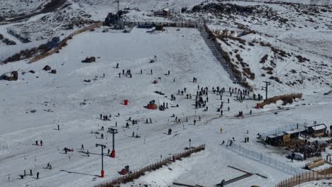 Aerial-establishing-shot-of-crowds-of-people-skiing-and-snowboarding-at-El-Colorado