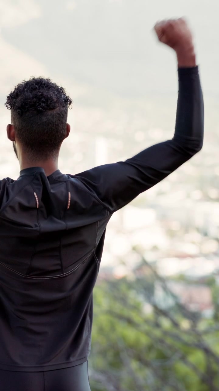 Hombre atlético celebrando el éxito con vista panorámica de la ciudad