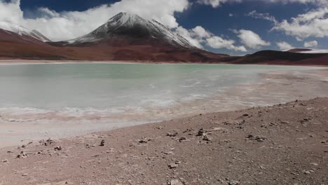 snow capped volcano with blue lake in bolivia