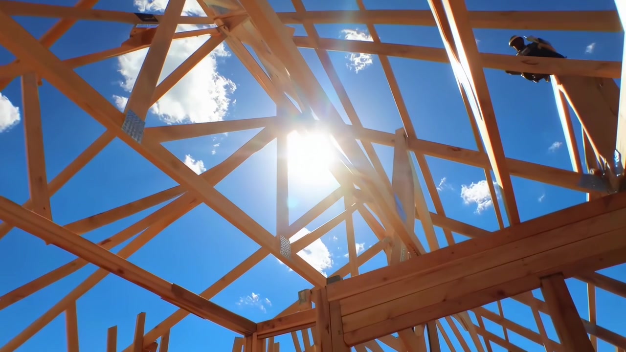 Holzrahmenbau eines Hauses im Bau mit blauem Himmel und Sonne