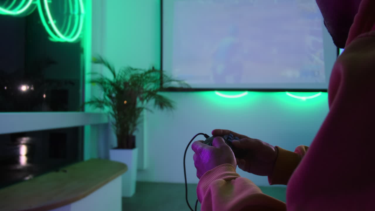 Persona che gioca a un videogioco in una stanza elegante illuminata al neon