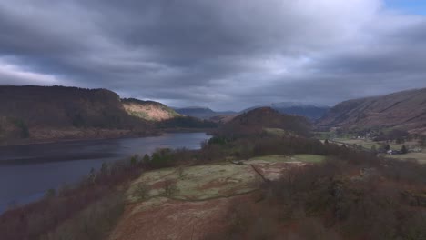 lateral flight over landscape towards lake at dawn.lake district, cumbria, uk.