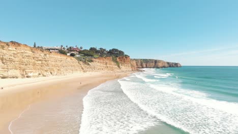 waves washing on sand beach and cliffs of lagos coastline