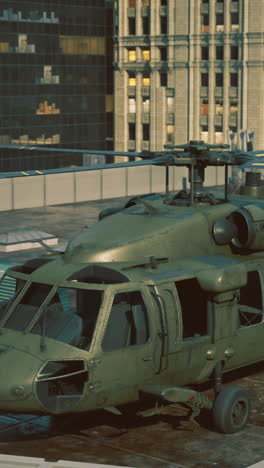 glowing city lightsa military helicopter is stationed on a tall buildings rooftop
