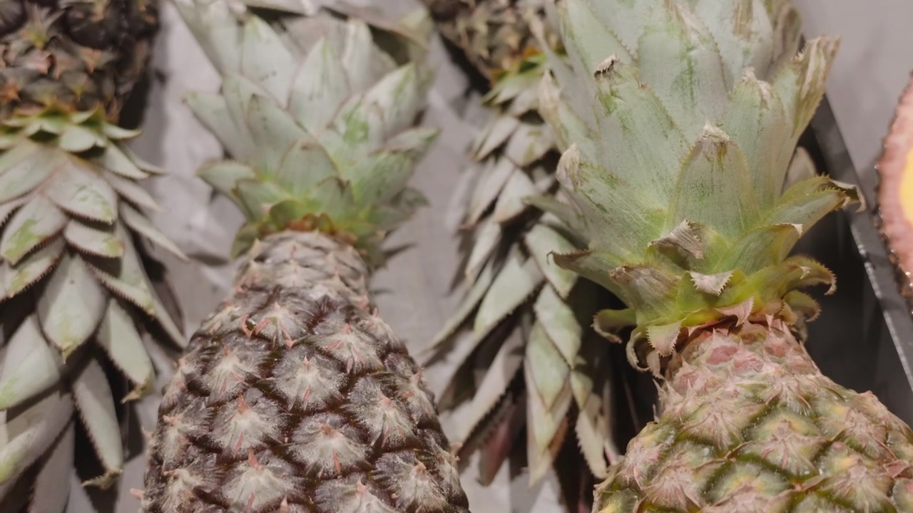 Close-up of fresh pineapples with spiky green crowns on display at a market, Cote d'Azur, France