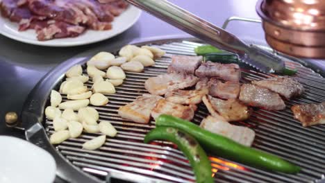 cooking pork belly and garlic on a grill