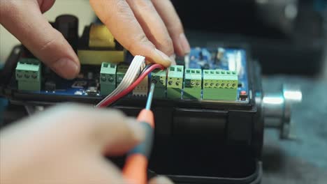 the man combines the main board of the door motor with a screwdriver