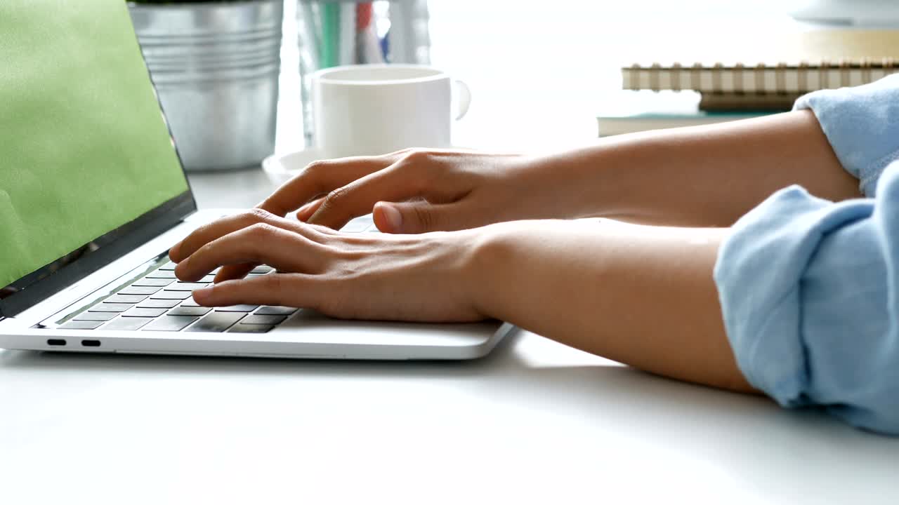 Close up hand typing on a Keyboard computer laptop at office. One young woman only using computer desktop PC.