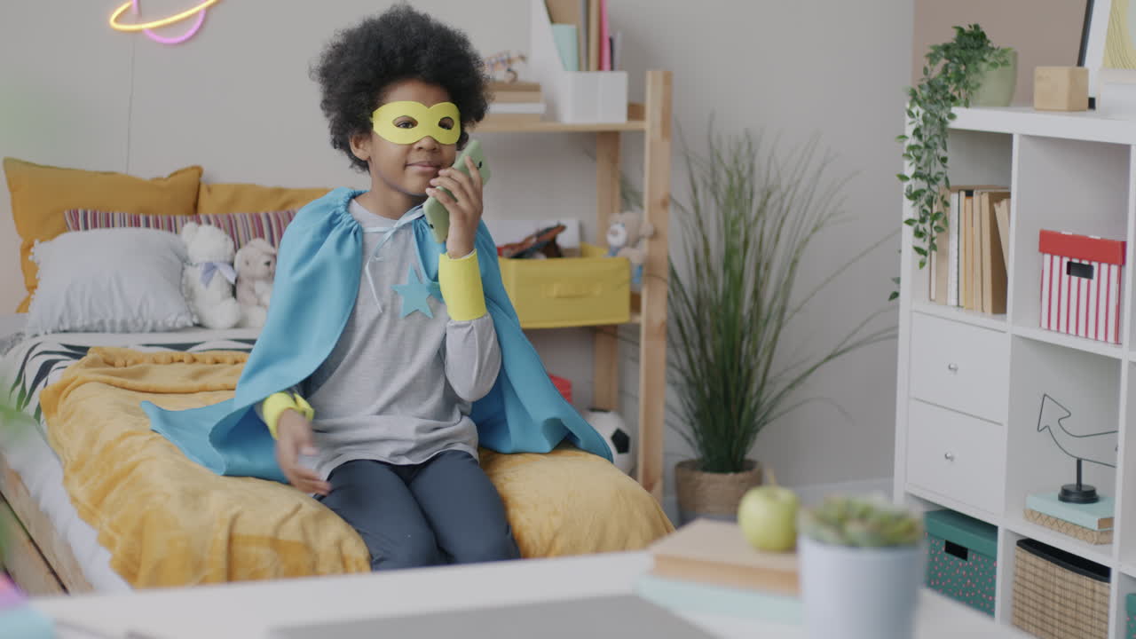 Child Superhero Talking on Phone in Bedroom