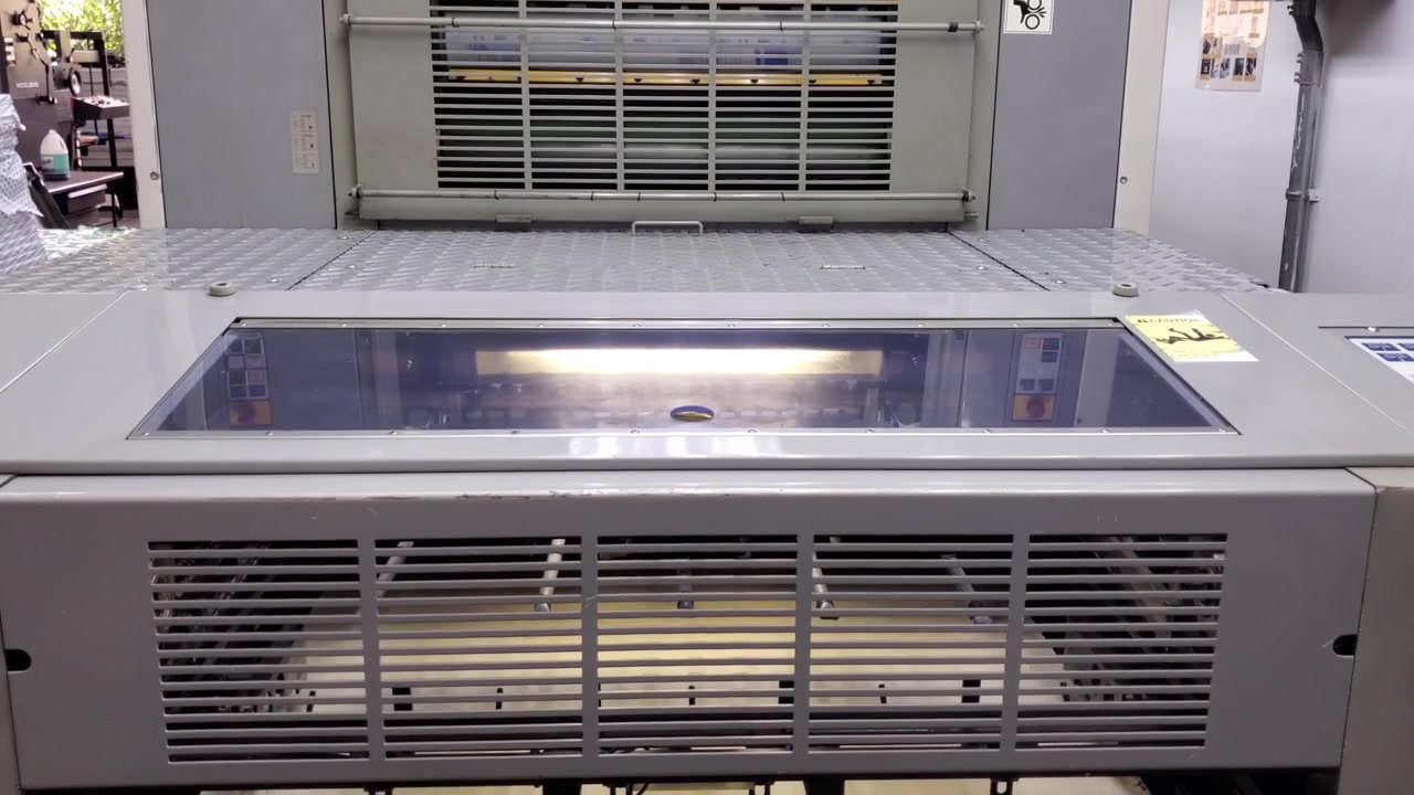 tilt-up shot of an automated industrial printing machine in motion, showcasing modern manufacturing precision and production efficiency