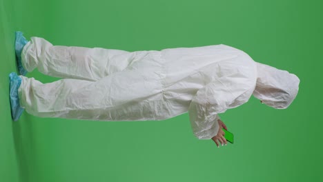 full body back view of asian male scientist use mock up green screen smartphone while standing on green screen background