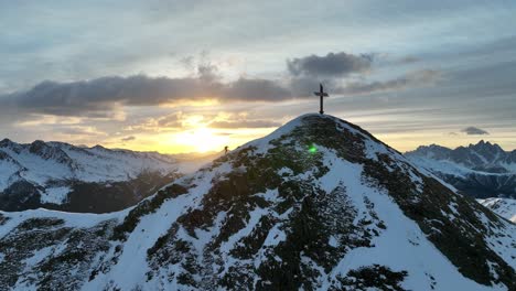 alpinista wspina się na ostatnie metry na szczyt podczas wschodu słońca we włoskich alpach