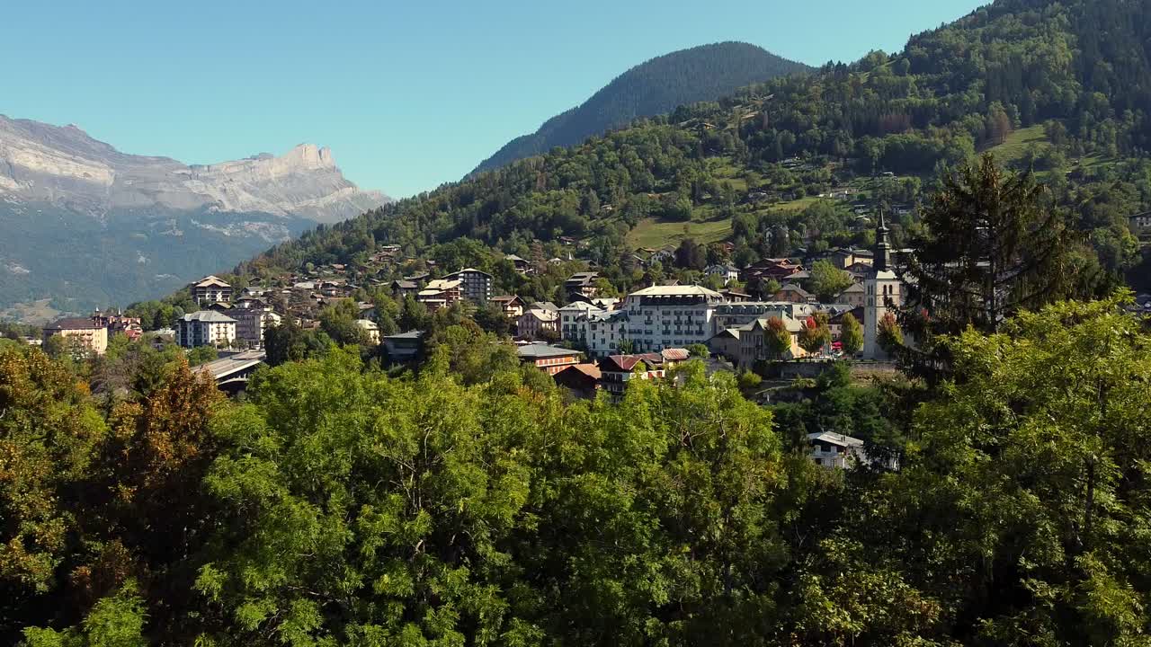 volando hacia abajo escondiendo un pueblo alpino detrás de un árbol