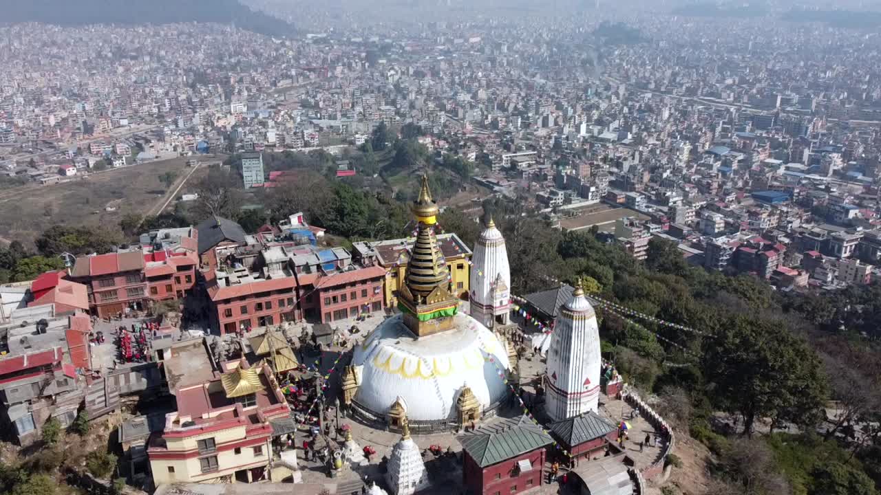 una vista de la estupa swayambhunath en la cima de una colina con la ciudad de katmandú, nepal y las montañas del himalaya en el fondo