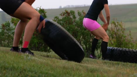 Side-view-of-fit-Caucasian-man-and-woman-exercising-with-tyre-4k