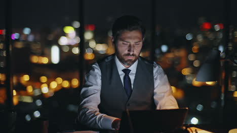 bearded manager working dark office. focused man executive browsing computer