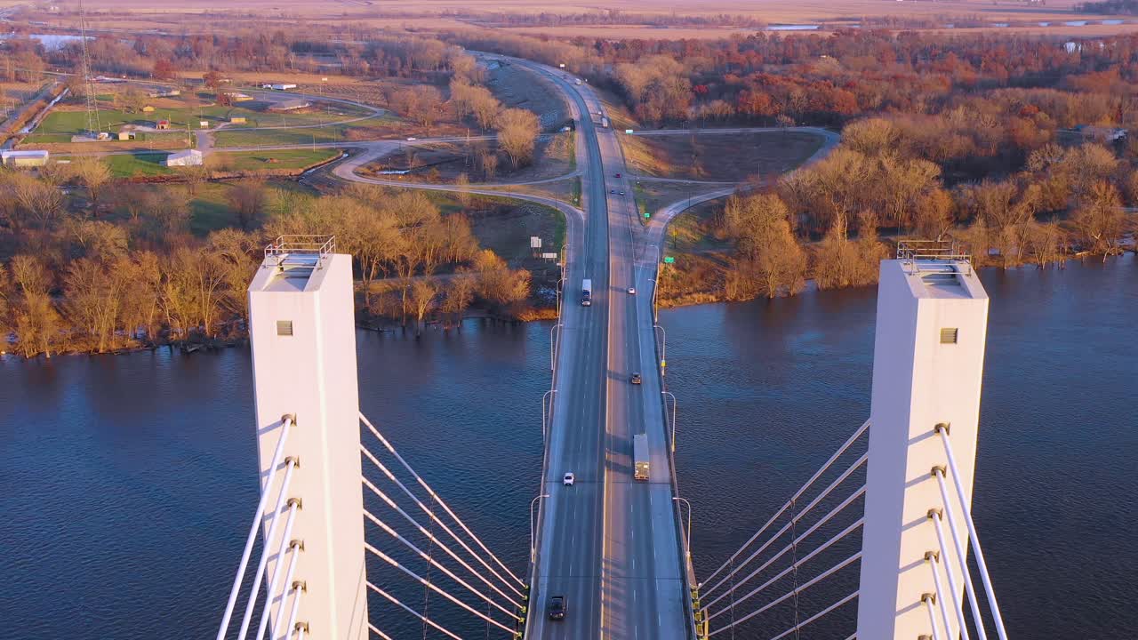 무인 항공기 공중 기울기는 인프라 운송 트럭 운송 또는 운송을 제안하는 벌링턴 아이오와에서 미시시피 강 다리를 건너는 상업용 트럭을 따라갑니다.