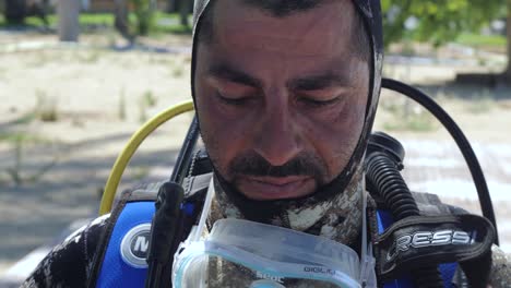 primer plano de un buzo masculino poniéndose la máscara antes de una inmersión