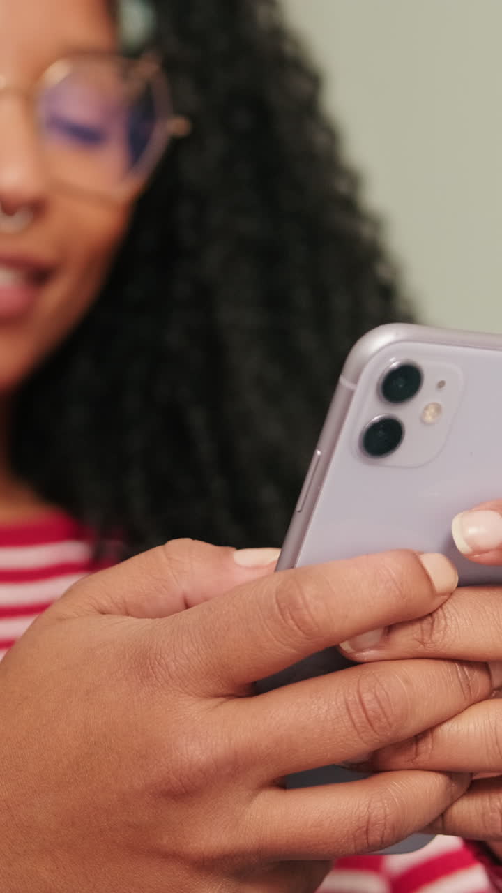Giovane donna che sorride mentre usa lo smartphone