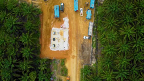 Cinematic-Drone-Footage-of-Onshore-Drilling-Rig-equipment-structure-for-oil-exploration-and-exploitation-in-the-middle-of-jungle-surrounded-by-palm-oil-trees-during-sunset-and-high-oil-price