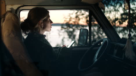 woman texting on smartphone in van