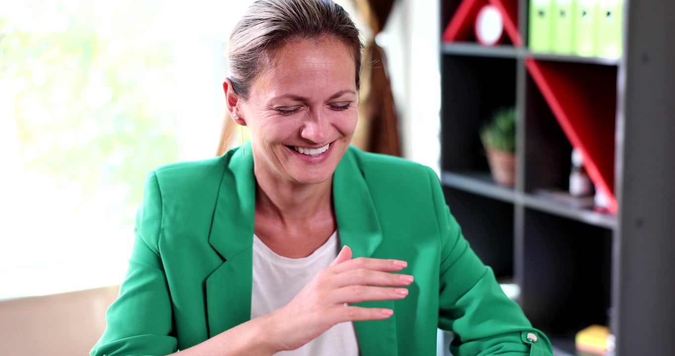 Risate gioiose riempiono la stanza mentre una donna condivide un momento sentito con gli amici