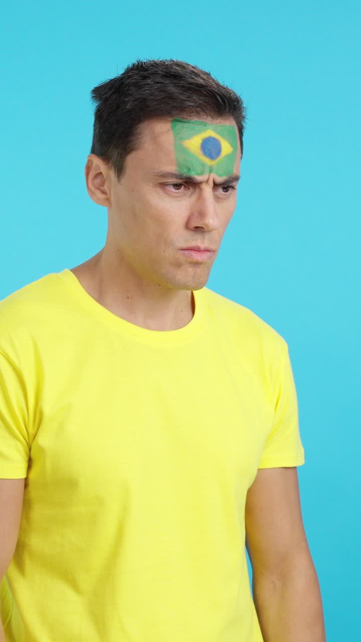 Brazilian patriot man looking away with serious expression