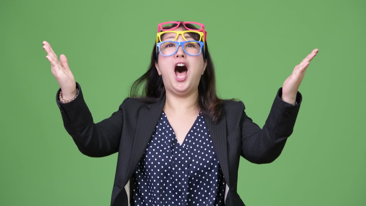 성숙한 아름다운 아시아 사업가 여성은 재미있는 개념으로 많은 안경을 착용합니다.