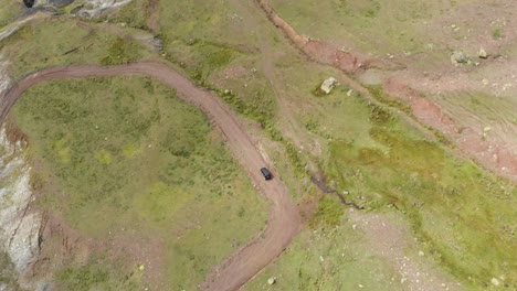 Drone-video-top-view-car-mountain-winding-dirt-road-Gramos-Greece-summer-sunny